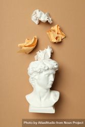 Marble bust with crumpled paper coming out of brain on brown background, vertical 0J8PZ4
