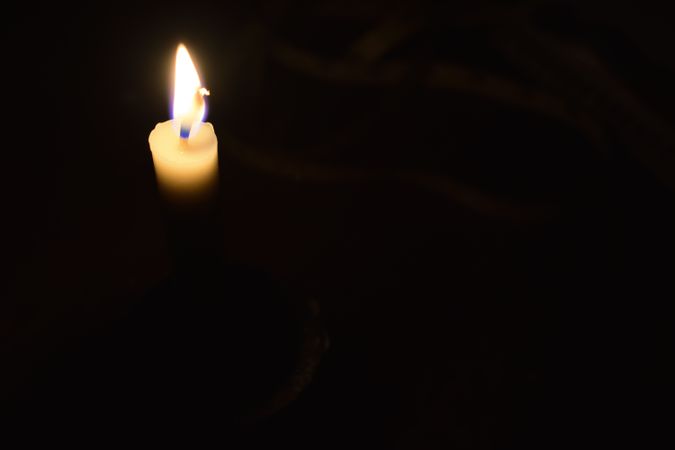 Top view of candle lit in the dark