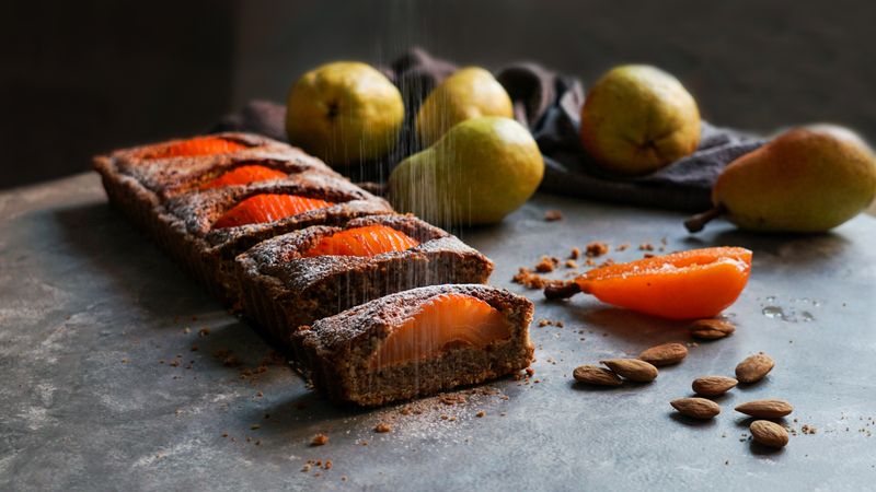 Pear cake and fruits on table