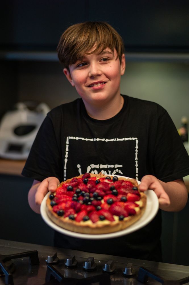 Boy holding strawberry tart