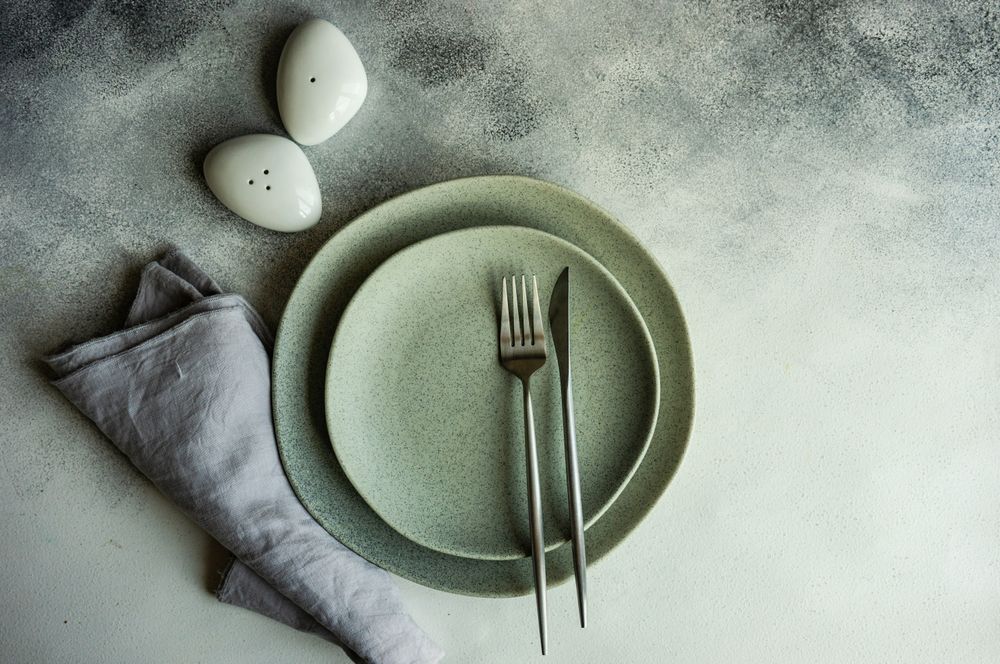 Elegant modern table setting, napkin, silverware with salt and pepper shakers with space for text