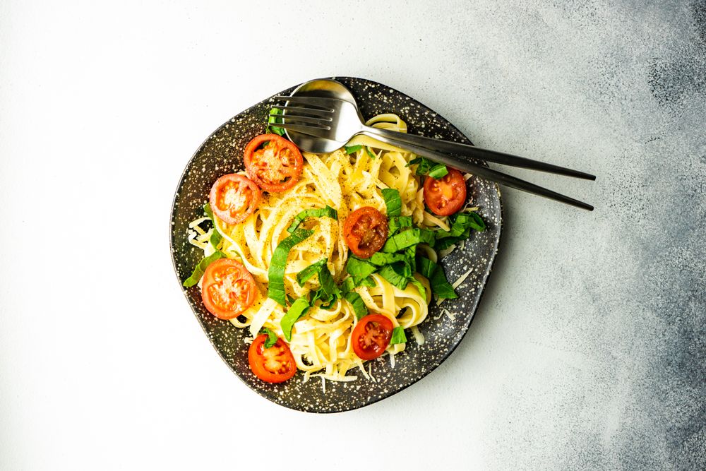 Top view of pasta with spinach and tomatoes