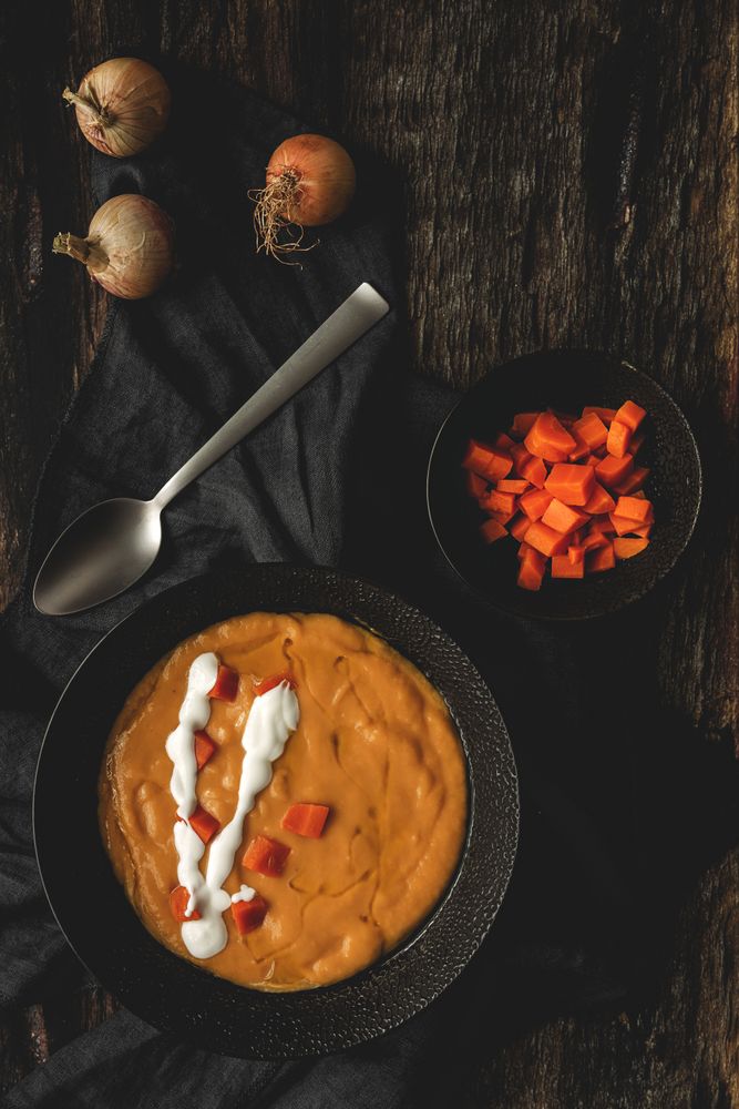 Orange cream soup and sliced carrot in bowls