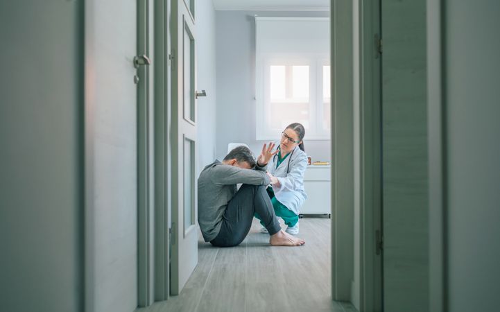 Female doctor trying to help male patient