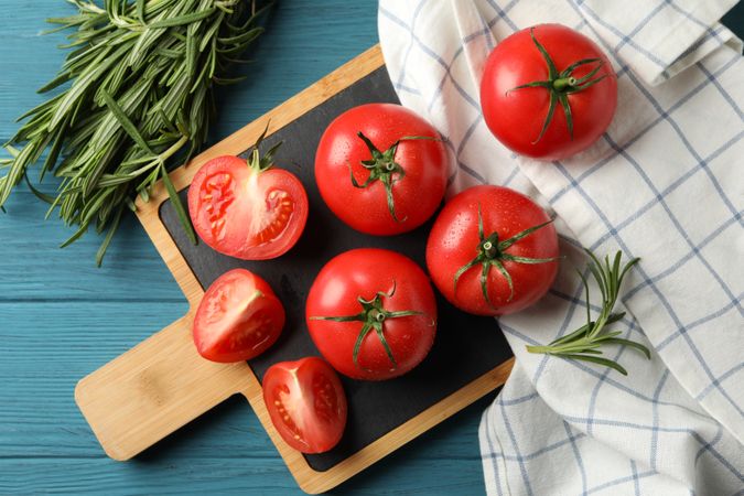 Composition with tomatoes and rosemary on wooden background, top view
