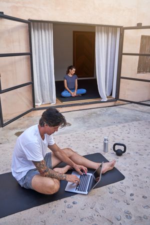Sportsman using laptop on terrace with sportswoman
