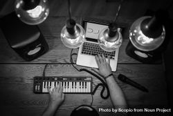 Grayscale photo of person creating music using digital keyboard and laptop indoor 0vWqG5