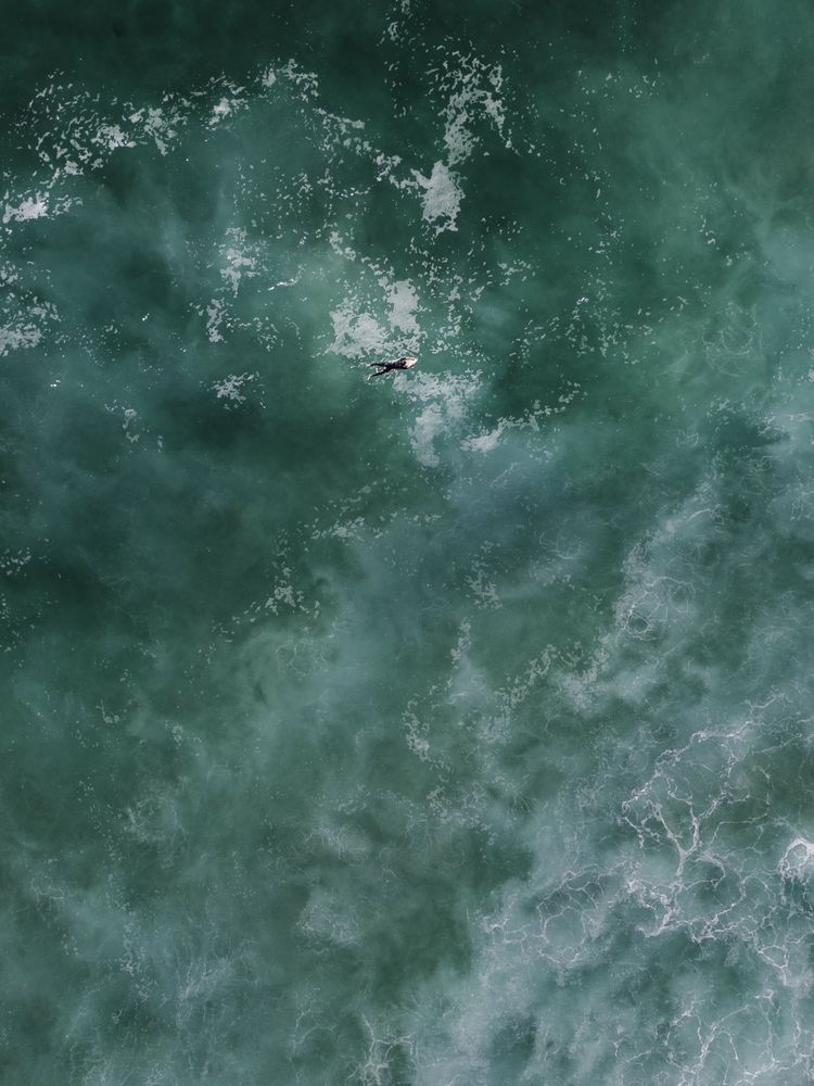 Top view of surfer in dark blue ocean water