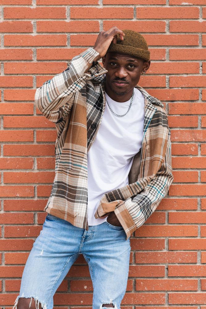 Stylish Black man against brick wall