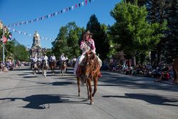 Woman riding horse back during a parade during Cheyenne Frontier Days, Wyoming 0V6Ej0