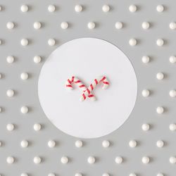 Holiday pattern with candy canes and snowballs on gray background
