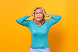 Disgusted Muslim woman with hands on her head