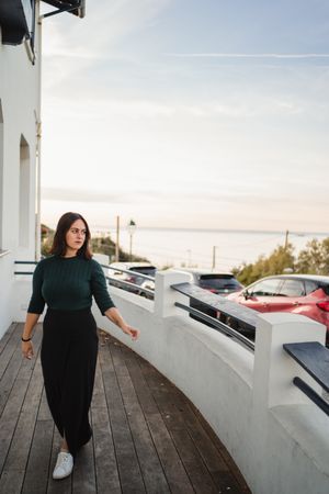 Pensive woman walking on balcony