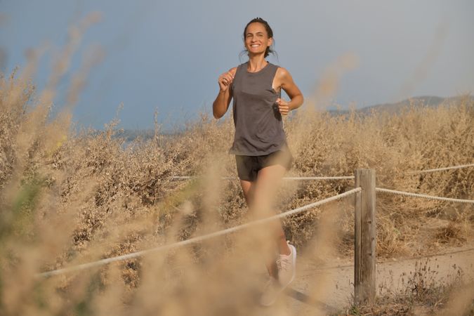 Young woman admiring dry fields while running