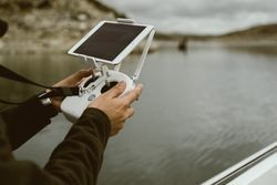 Person controlling device using tablet on stand in hands