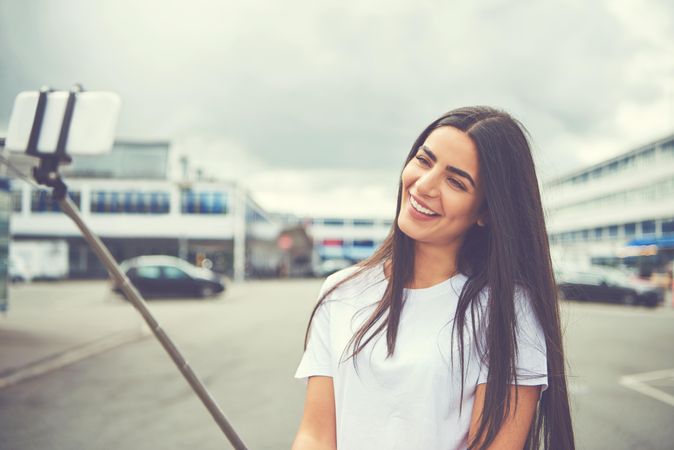 Woman smiling calmly at selfie stick