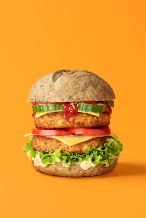 Vegan burger close-up isolated on an orange background