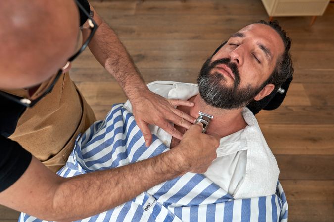 Professional barber cutting hair of client in