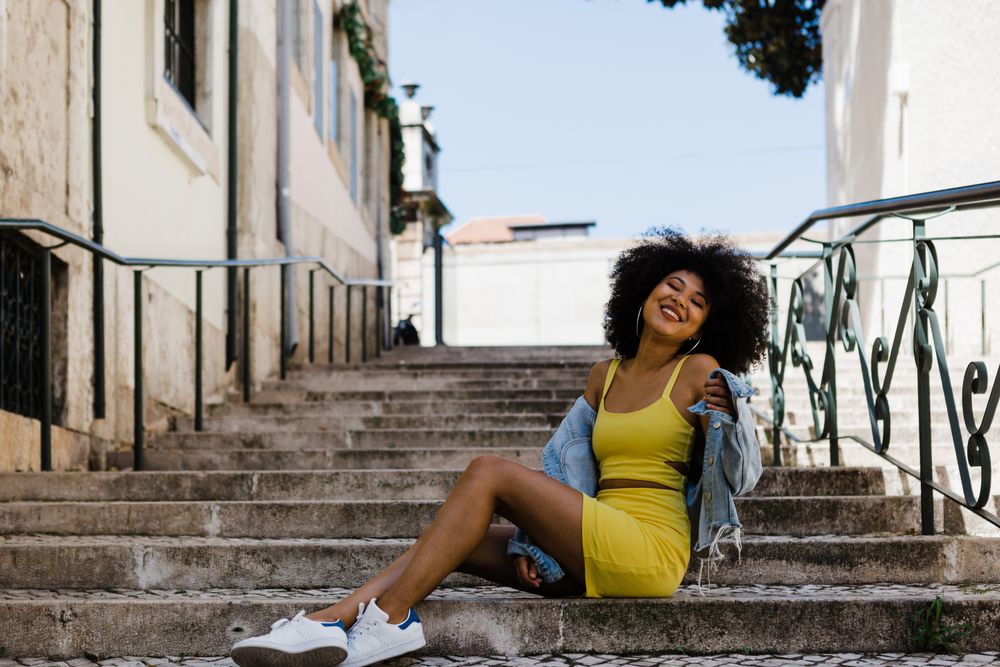 Stylish female standing in stairs with railing outdoors