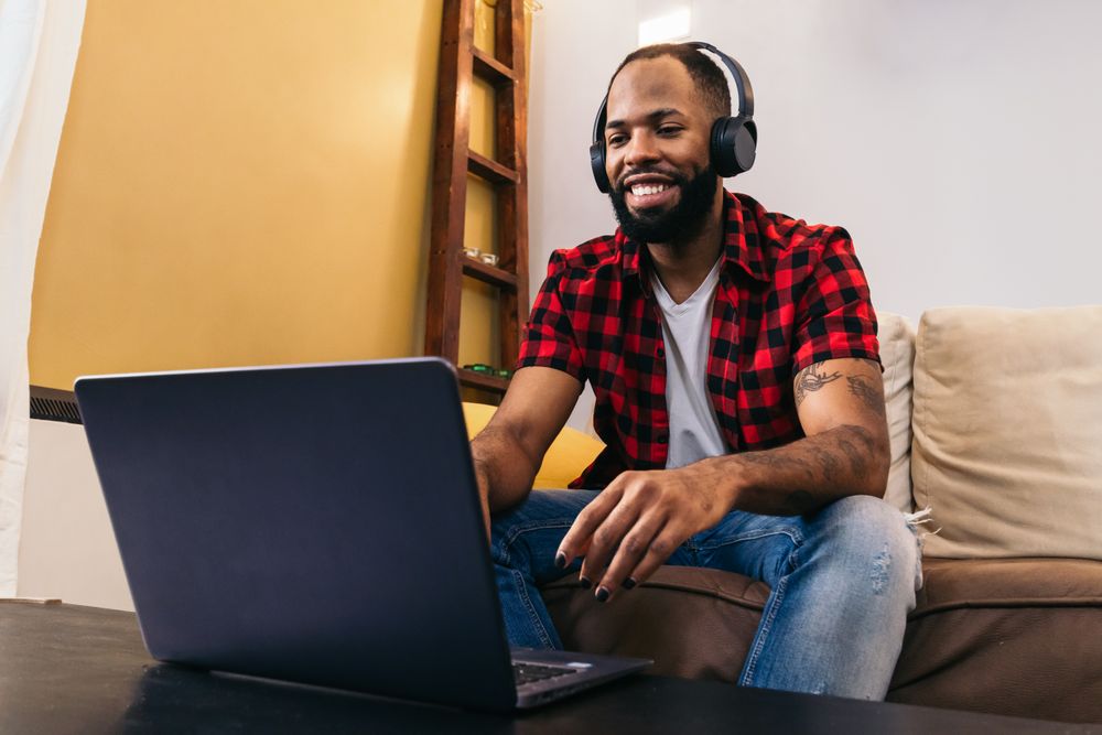 Black man making work video call with laptop at home
