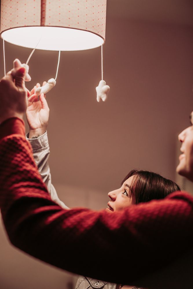 Expecting couple lighting chandelier in baby room