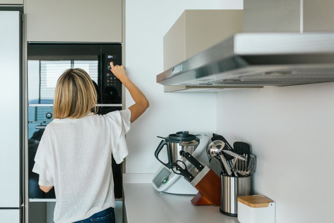 Woman turning on microwave oven