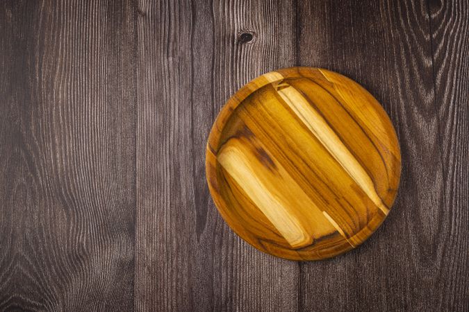 Empty plate on the wooden table. Top view of the image.