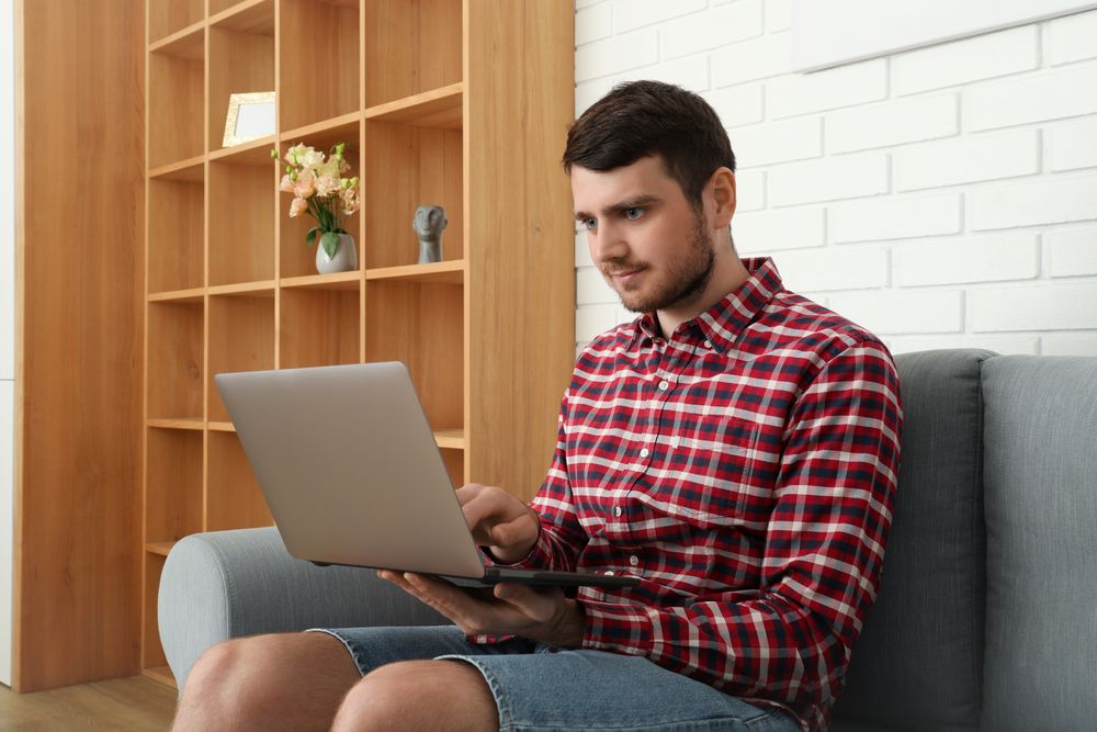 Young man working on laptop in modern flat