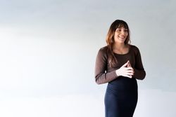 Smiling transgender woman standing in a bright room