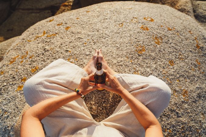Woman relaxing and drinking beer at beach
