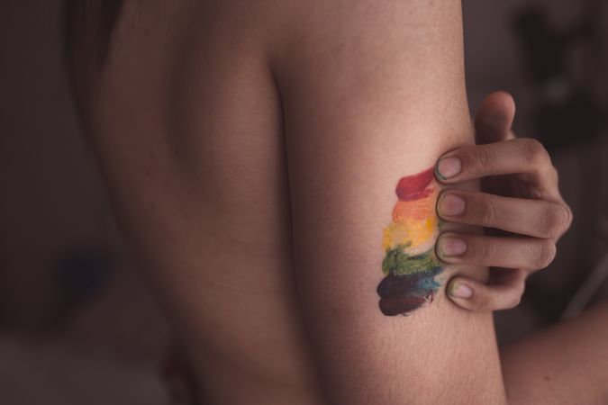 naked woman covering breast and drawing LGBTQIA symbol