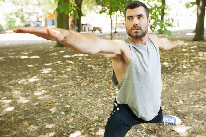 Sporty man stretching up in park