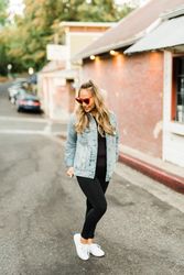 Woman in denim jacket standing on road