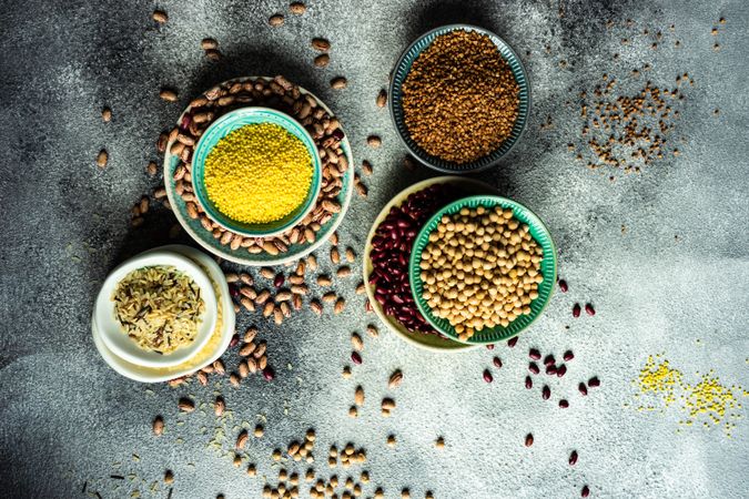 Top view of bowls of dried grains and legumes from pantry