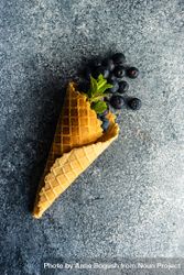 Waffle cone with fresh blueberries on grey counter 4Zek23