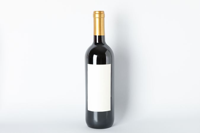 Bottle of red wine on grey background, space for text