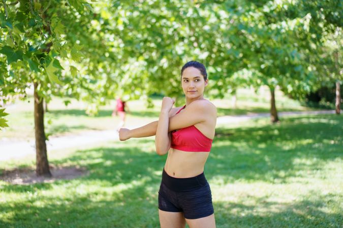 Woman stretching arms in park