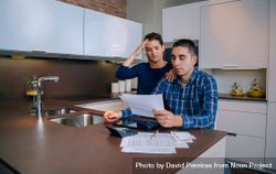 Tense couple organizing bills together in their kitchen bYowg5