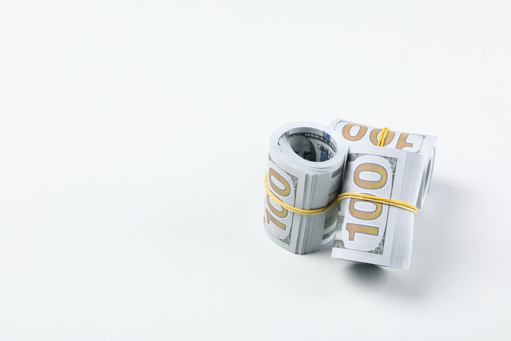 Twisted money with a rubber band, on a light background.