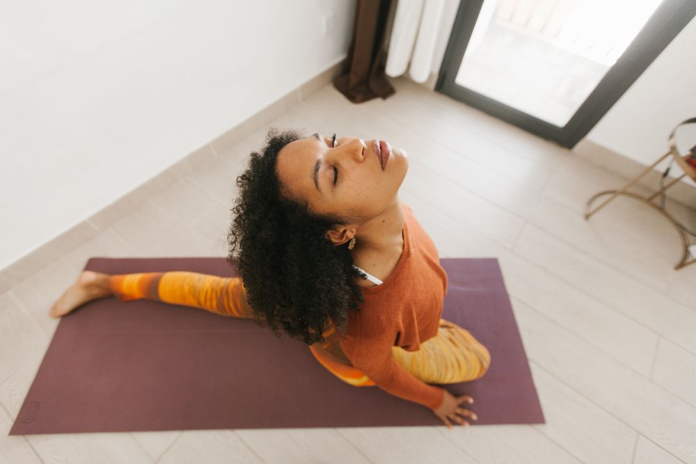 Sportive woman performing yoga pose in room