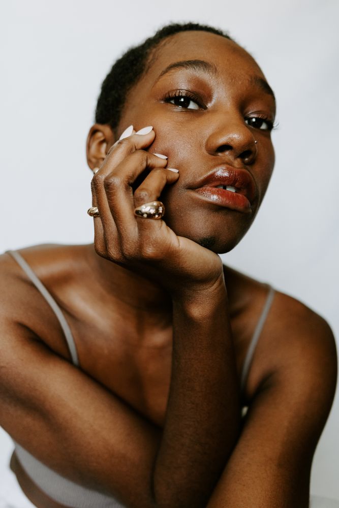Woman resting head in hand wearing red lip-gloss