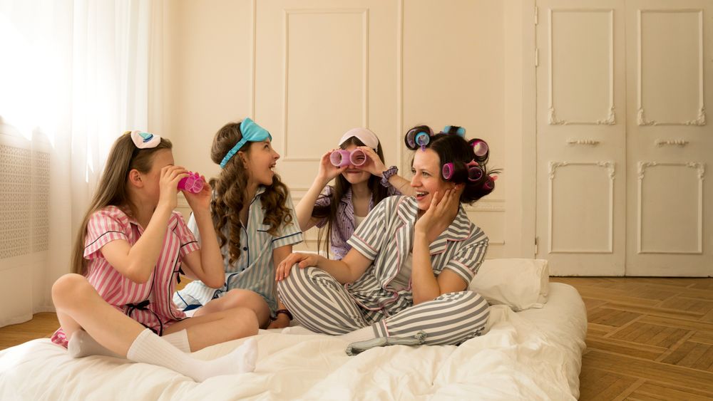 Girls enjoying playful moment with hair rollers and pajamas