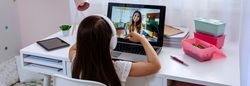 Girl at home receiving online class from her teacher
