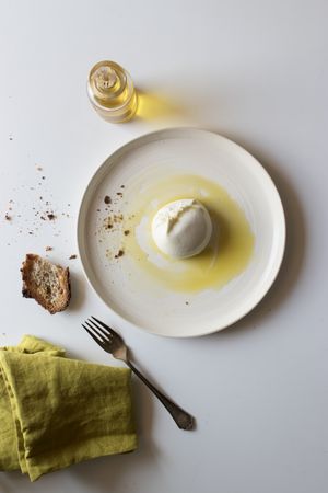 Plate with cheese near bread and condiments