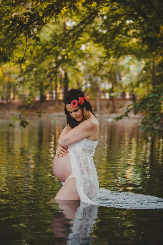 Pregnant woman standing in lake water