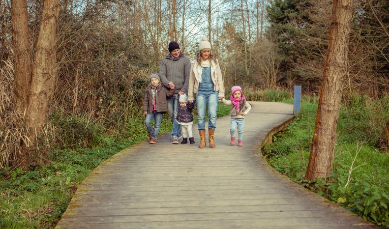 Family of 5 walking along forest trail