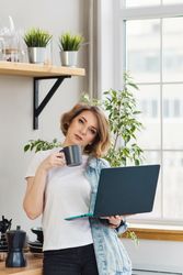 Freelancer Workplace In Kitchen With Laptop Sipping Coffee