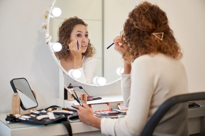 Woman applying eyeshadow in beauty salon