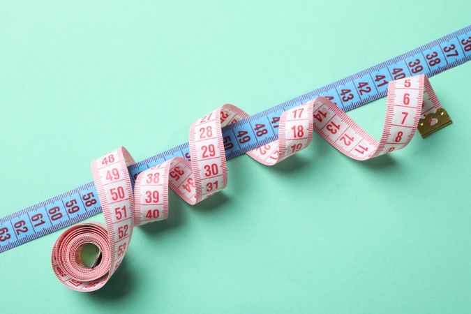 Measuring tape on mint background. Weight loss concept