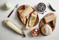 Dough near corn husk and spices for tamales